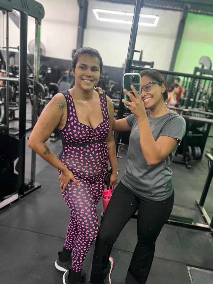 Lis abraçando uma aluna em selfie na academia